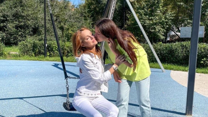 В кадре Марина Абросимова позирует во время прогулки по скверу.