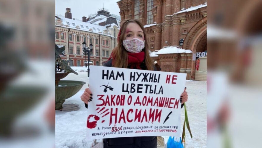 Девушка стояла с плакатом у Богоявленского собора.