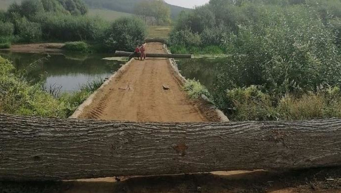Некоторые переправляются через небольшой водоем в деревне Туба.