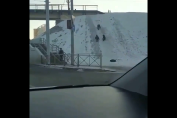 Трое несовершеннолетних детей устроили игры на снежном склоне в нескольких метрах от дороги.