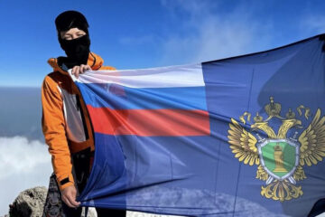 Екатерина Гудкова сфотографировалась с флагом ведомства на вершине горы.
