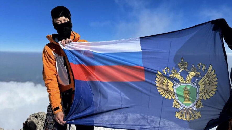 Екатерина Гудкова сфотографировалась с флагом ведомства на вершине горы.