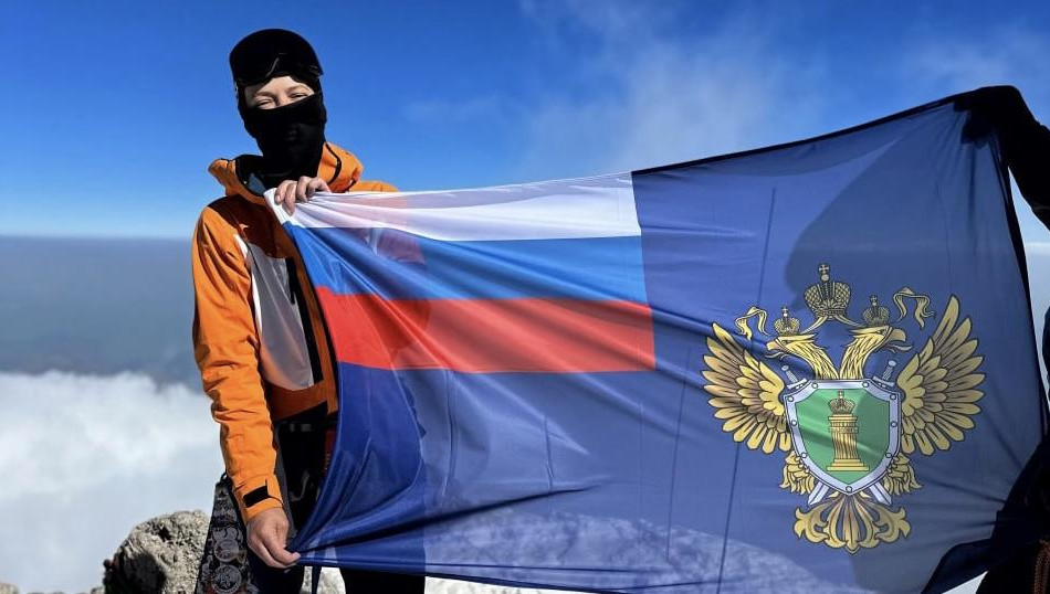 Екатерина Гудкова сфотографировалась с флагом ведомства на вершине горы.