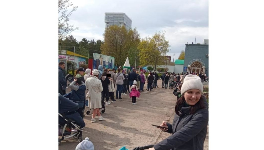 В огромной очереди под дождем простаивали десятки человек.