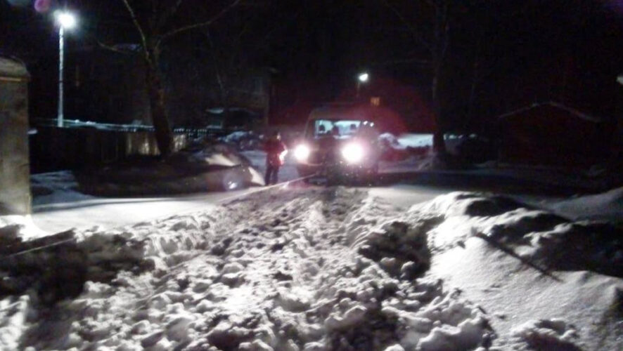 Машина женщины застряла в снежном заносе ранним утром.
