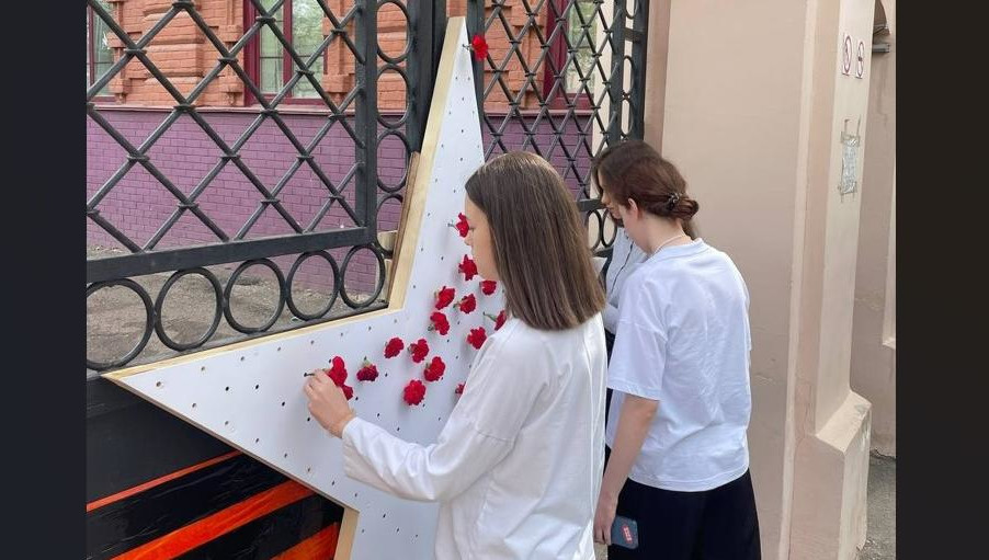 Ученики школы уже принесли цветы к декорации